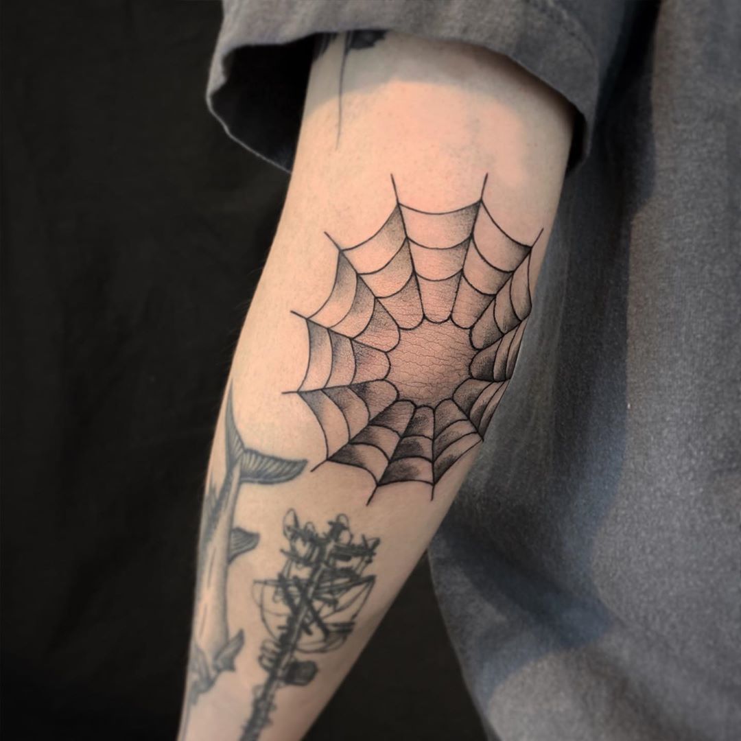 Black and grey spider web elbow tattoo