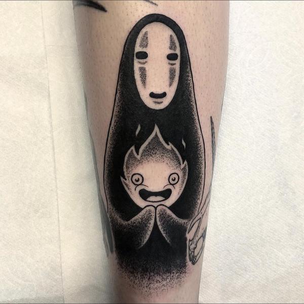 Black and white No Face with Calcifer tattoo on forearm