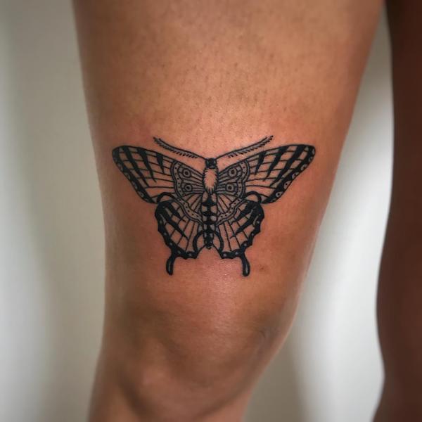 Black and white butterfly tattoo above knee