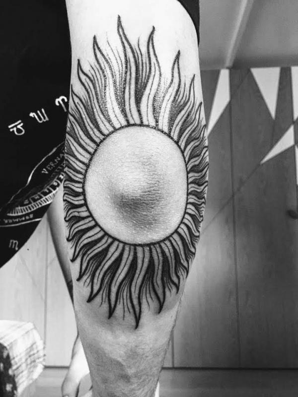 Black and white firing sun elbow tattoo