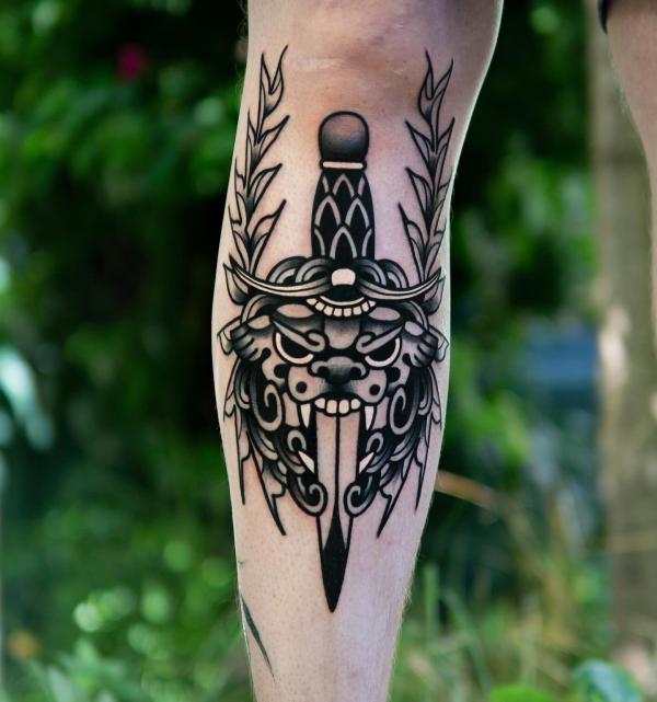 Black and white foo dog and dagger tattoo