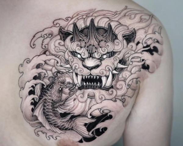 Black and white foo dog and koi fish chest tattoo
