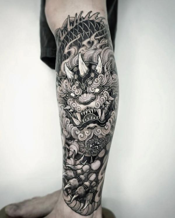 Black and white foo dog lower leg tattoo