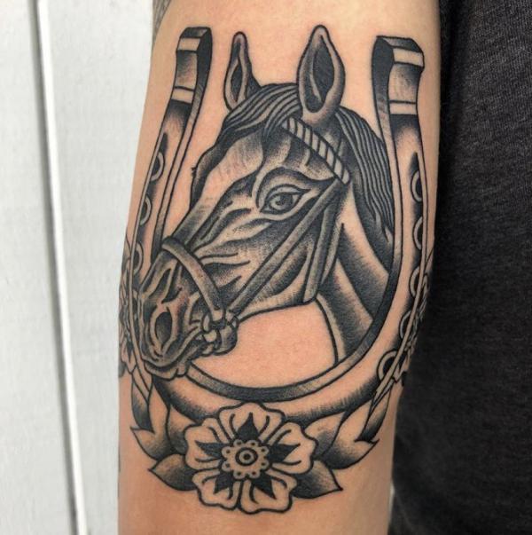 Black and white horse and horseshoe tattoo