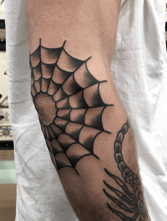 Black and white spiderweb elbow tattoo