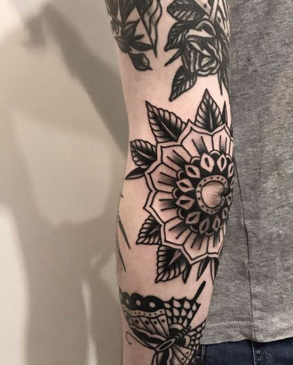 Black and white tradiitional flower elbow tattoo