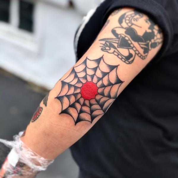 Black and white traditional spiderweb tattoo on elbow