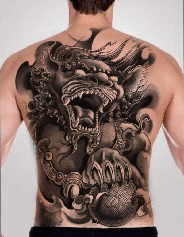 Black ink foo dog with ball back tattoo