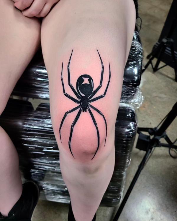 Black widow spider tattoo above knee