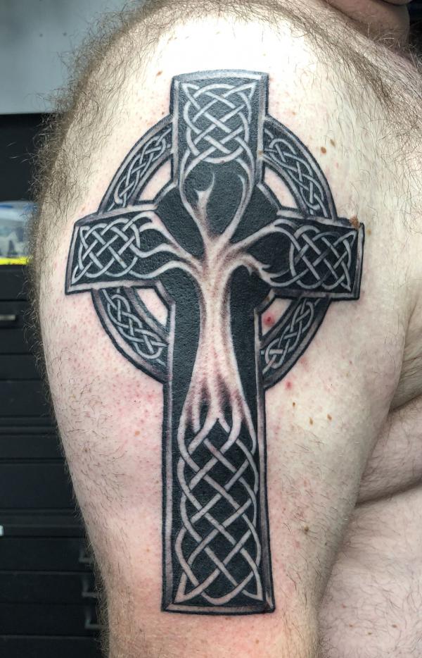 Blackwork Celtic cross with tree of life upper arm tattoo