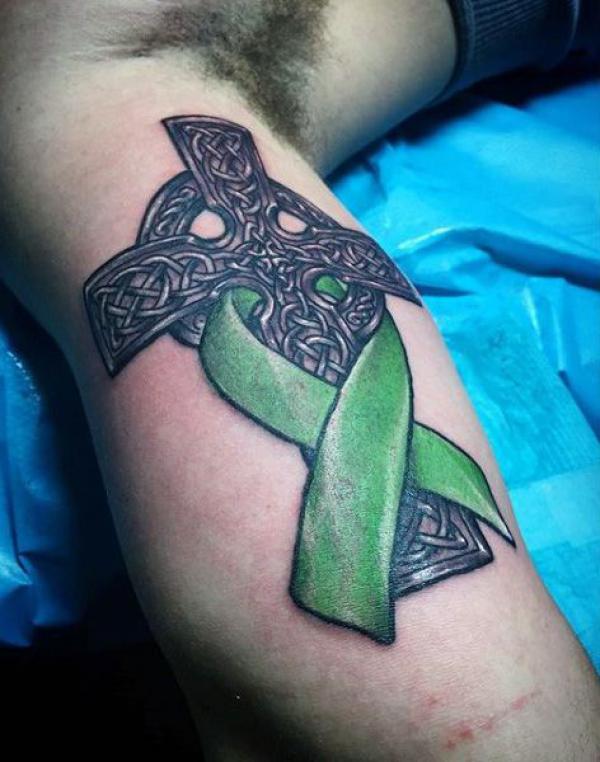 Blackwork cross with cancer ribbon tattoo