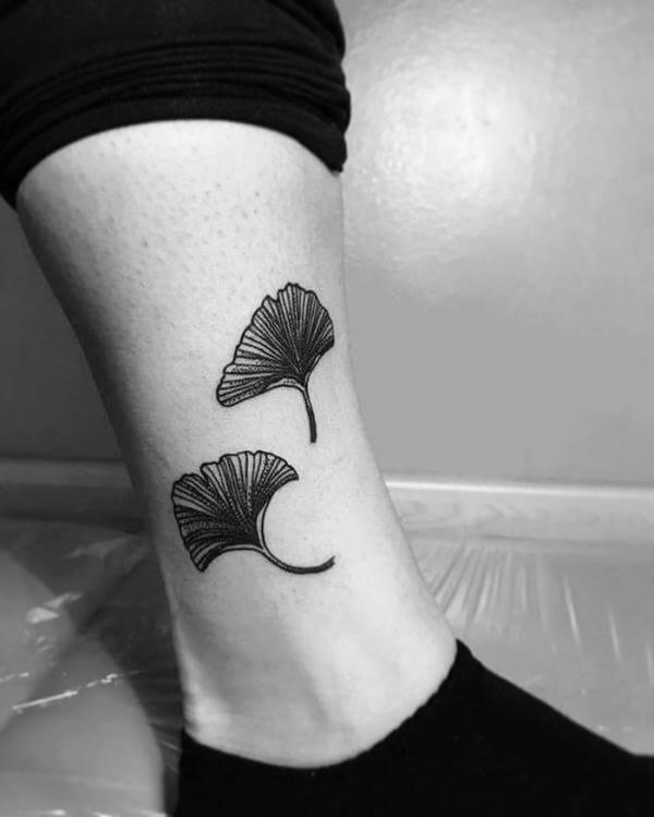 Blackwork ginkgo leaf tattoo above ankle