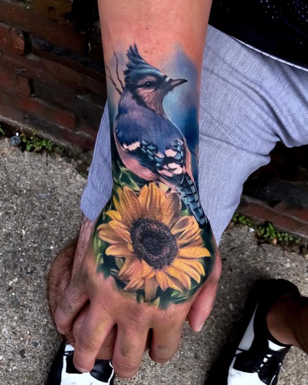 Blue Jay and sunflower tattoo on hand