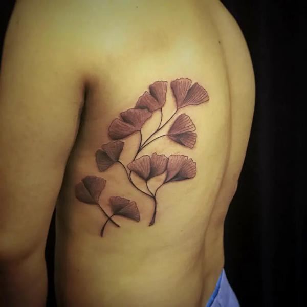 Brown ginkgo leaf rib cage tattoo