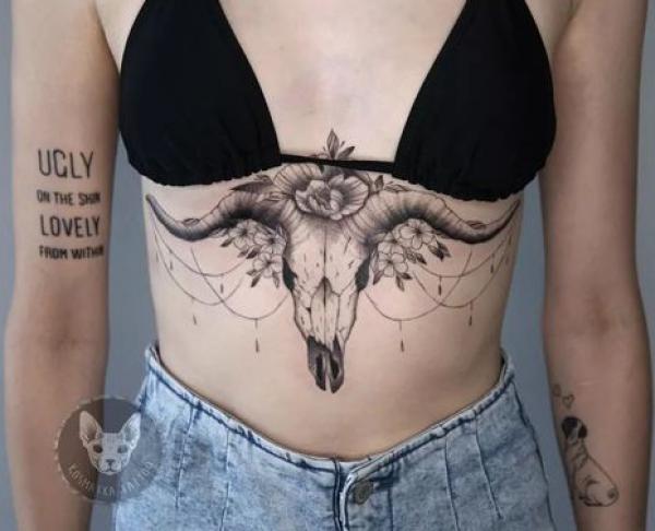 Bull skull with rose and pendant sternum tattoo