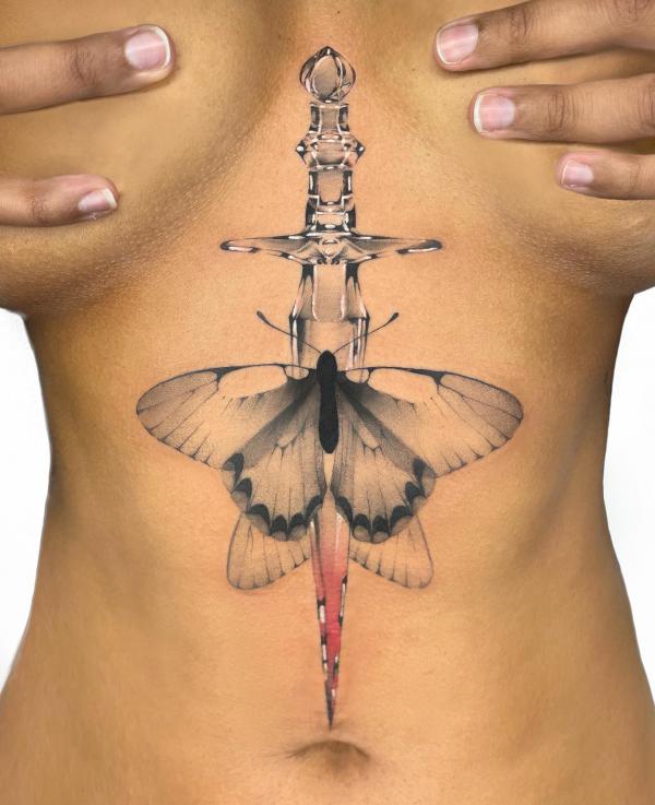 Butterfly with dagger underboob tattoo