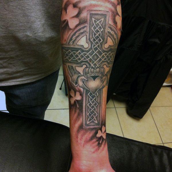 Celtic cross with claddagh and negative space clover tattoo