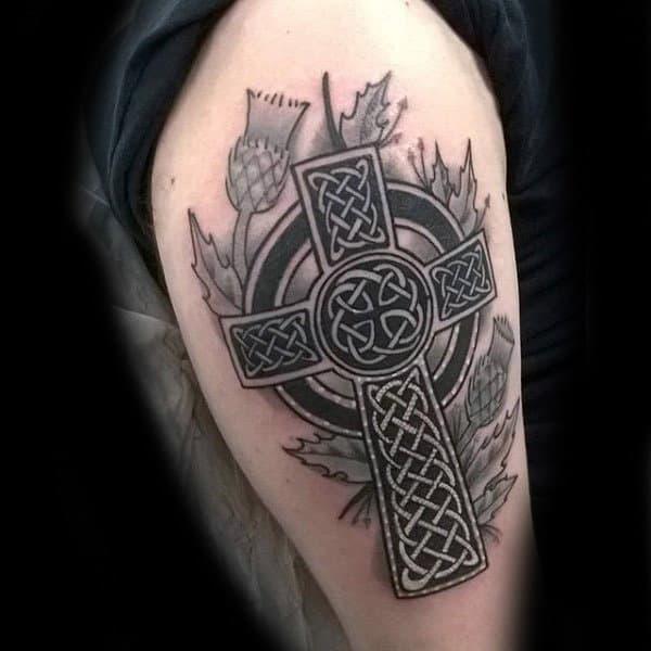 Celtic cross with thistle upper arm tattoo