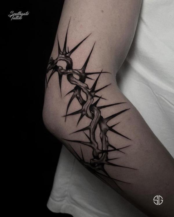 Dark barbed wire elbow tattoo