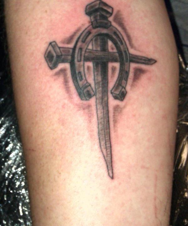 Dark horseshoe and cross tattoo