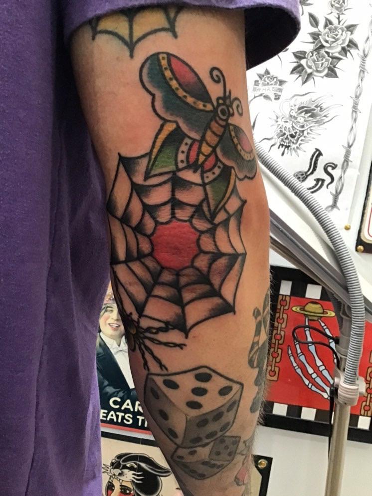 Elbow spiderweb with dice and butterfly tattoo traditional