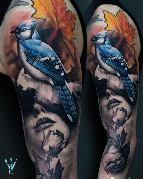 Female holding a rose with blue jay and maple leaf half sleeve tattoo