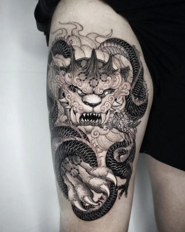 Foo dog and Dragon thigh tattoo black and white