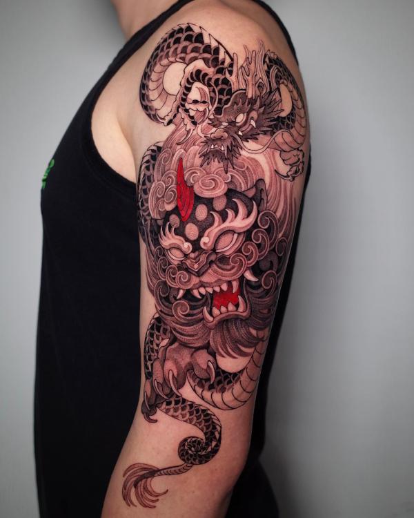 Foo dog and dragon tattoo on up arm