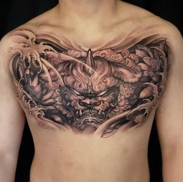 Foo dog in wave chest tattoo