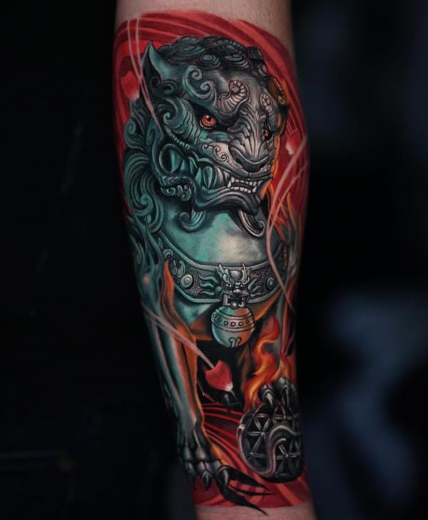 Foo dog with ball forearm tattoo