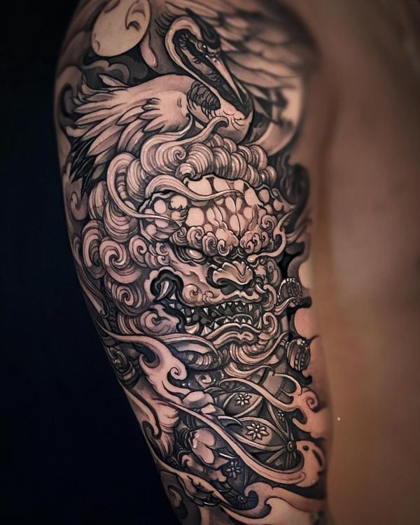 Foo dog with crane half sleeve tattoo