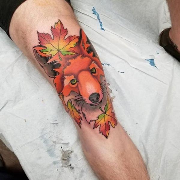 Fox and maple leaf tattoo above knee