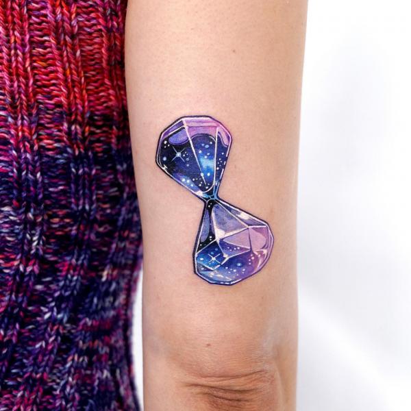 Galaxy hourglass back of arm tattoo