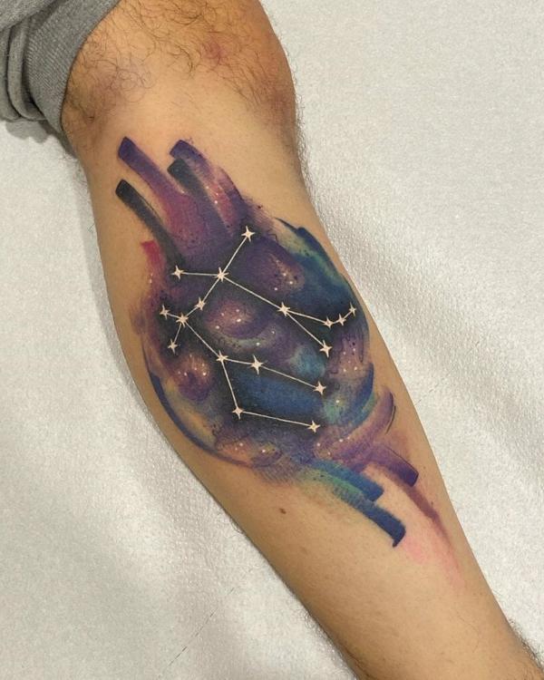 Gemini constellation on purple watercolor backdrop tattoo