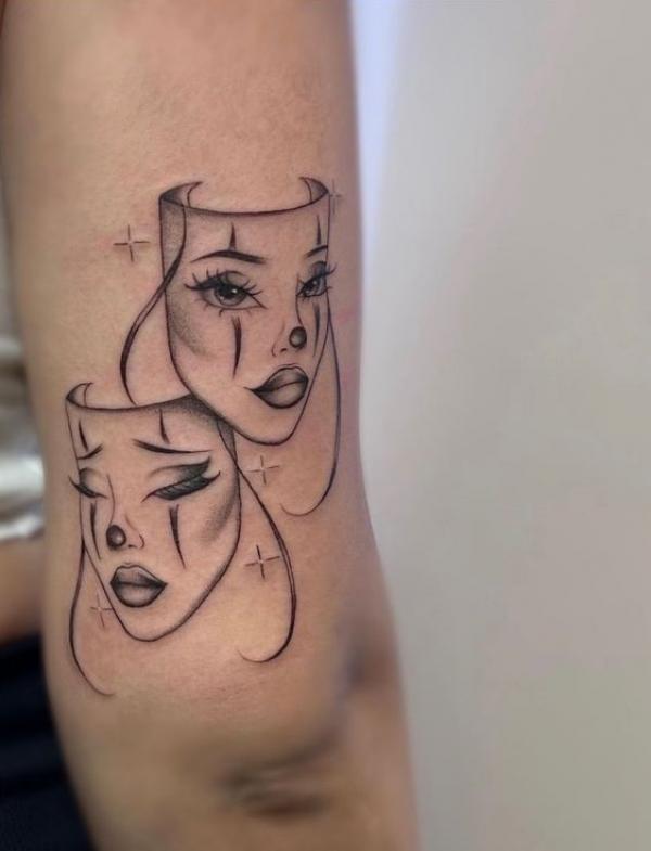 Gemini face above elbow tattoo
