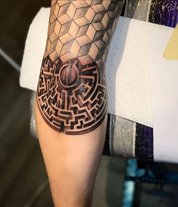 Geometric circular maze and piling cubes elbow tattoo