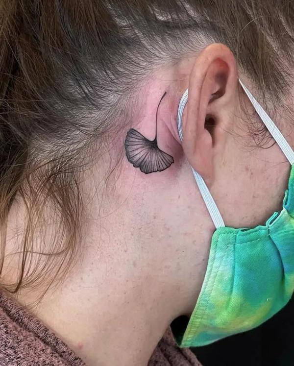 Ginkgo leaf tattoo behind the ear