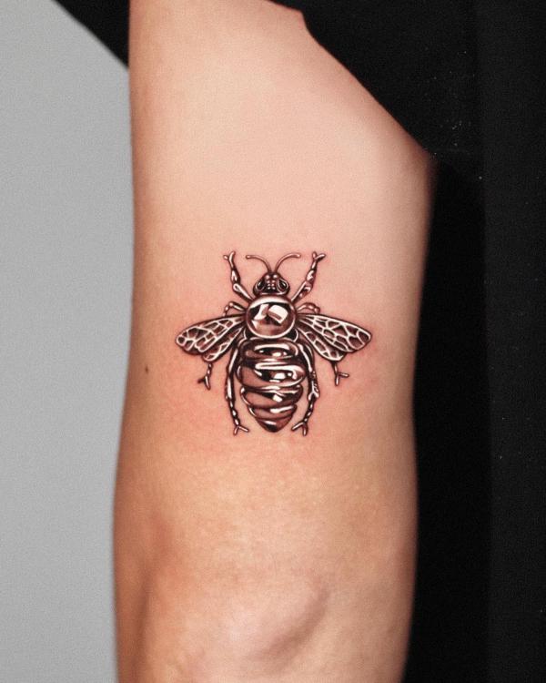 Golden bee back of arm tattoo