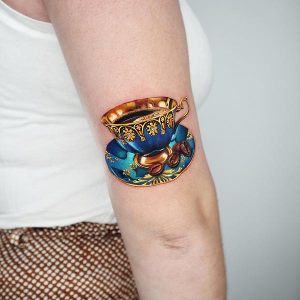 Golden bowl and dish back of arm tattoo