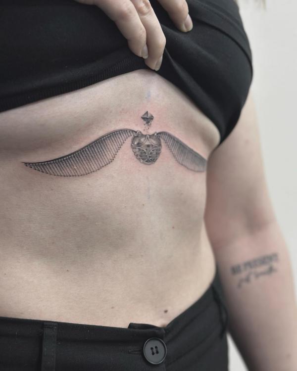 Golden snitch sternum tattoo