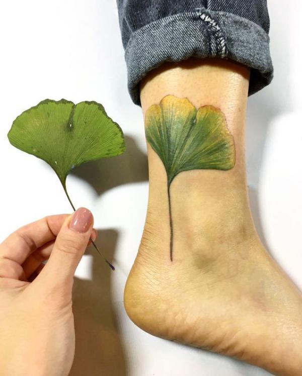 Green ginkgo leaf ankle tattoo