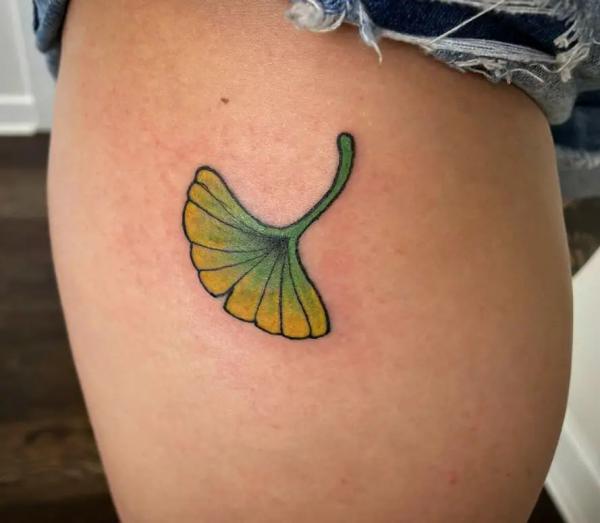 Green ginkgo leaf hip tattoo