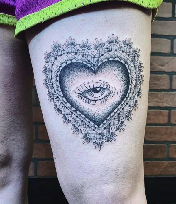 Heart with eye above knee tattoo