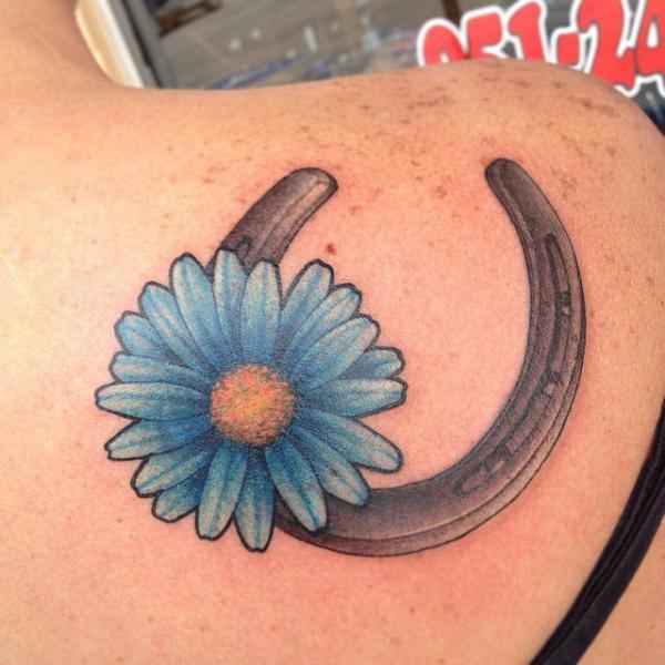 Horseshoe and blue daisy tattoo