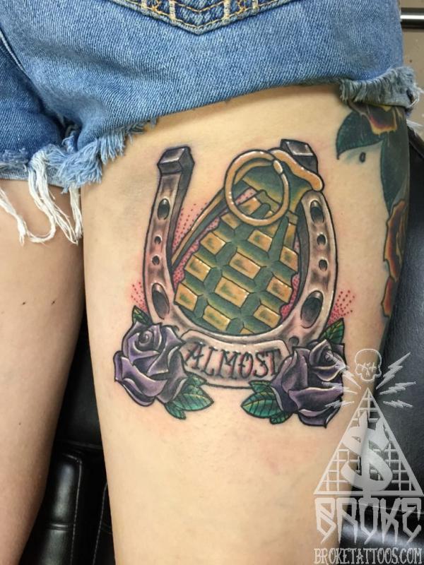 Horseshoe and hand grenade with rose tattoo