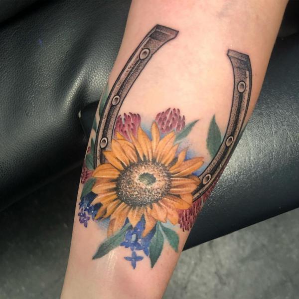 Horseshoe and sunflower tattoo on forearm