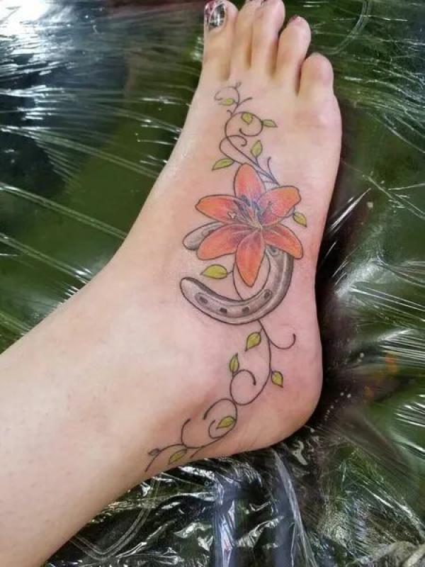 Horseshoe and tiger lily foot tattoo