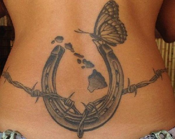 Horseshoe with barbed wire and butterfly low back tattoo