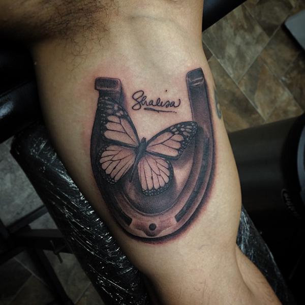 Horseshoe with butterfly bicep tattoo