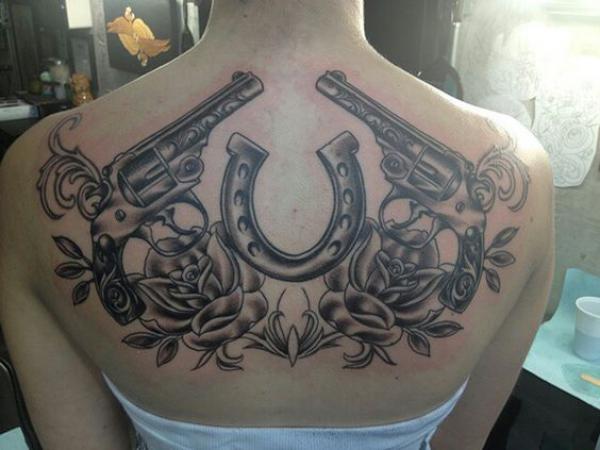 Horseshoe with rose and gun tattoo on back